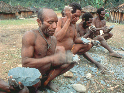 Papuan New Guinea men making stone tools